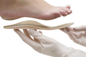 Orthèse qui est soutenue par des mains gantées sous le pied d'une personne